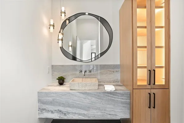 a bathroom with a granite countertop sink and a mirror