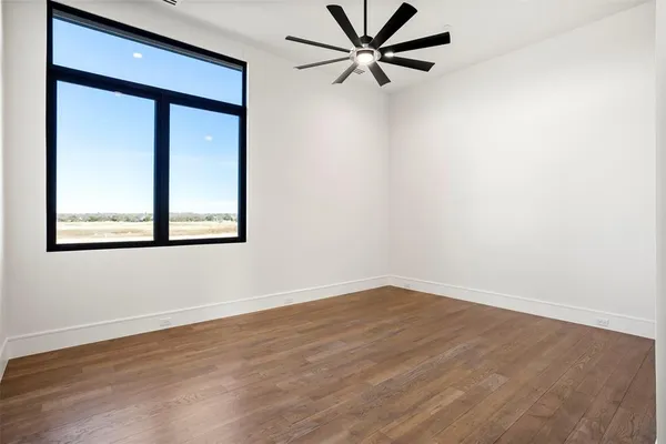 a view of a big room with wooden floor and a window