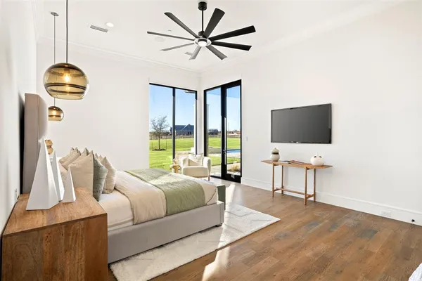 a bedroom with bed tv and a window