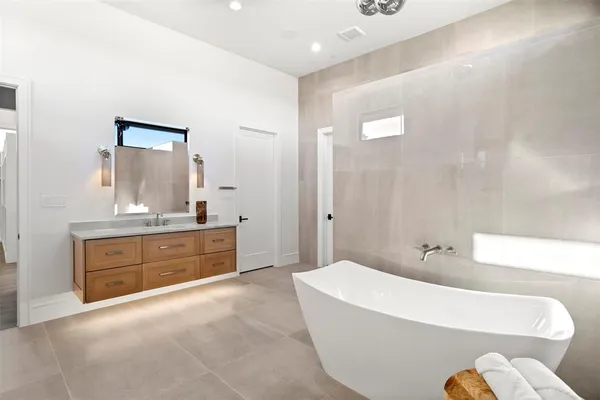 a bathroom with a tub sink and mirror