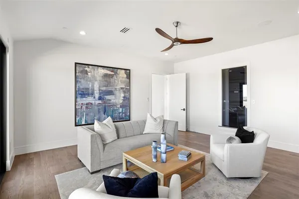 a living room with furniture and a wooden floor
