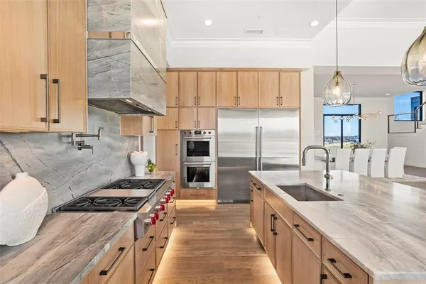 a kitchen with stainless steel appliances granite countertop a sink a stove and a refrigerator