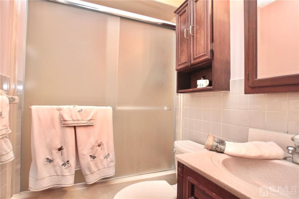 19 Kenmore Road Edison, NJ 08817 - Photo 7 of 13 a bathroom with a granite countertop sink a mirror and vanity