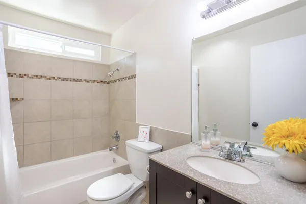 a bathroom with a granite countertop sink toilet and shower