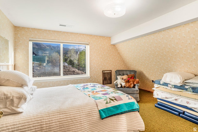 48 South Sage Road Pine Valley, UT 84781 - Photo 33 of 61 Bedroom featuring a large window, patterned wallpaper, textured carpet, and a ceiling-mounted light fixture