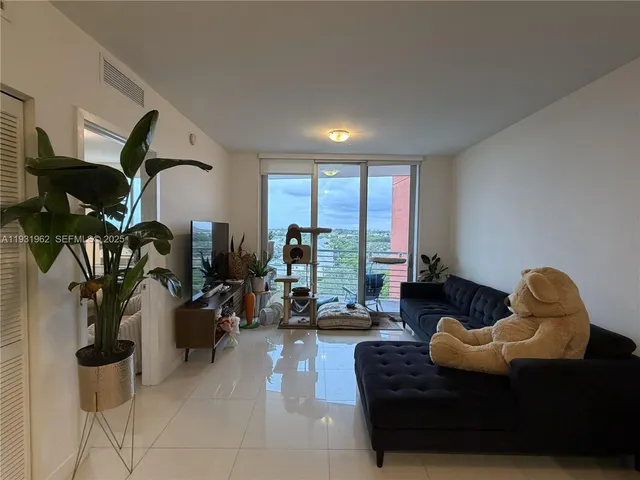 a living room with furniture and floor to ceiling window