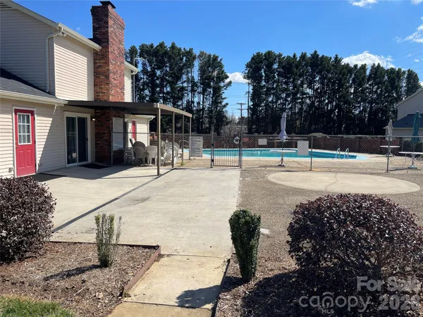 a view of a swimming pool with a bench and trees