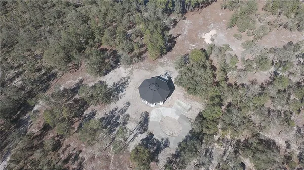 a aerial view of a house with a yard and large trees
