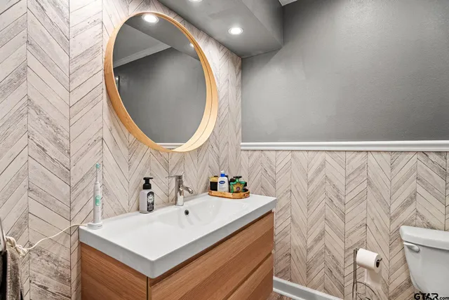 a bathroom with a sink a toilet and a mirror