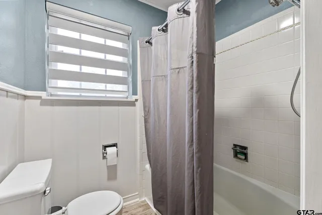 a bathroom with a toilet and a shower