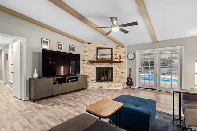a living room with furniture a flat screen tv and a fireplace