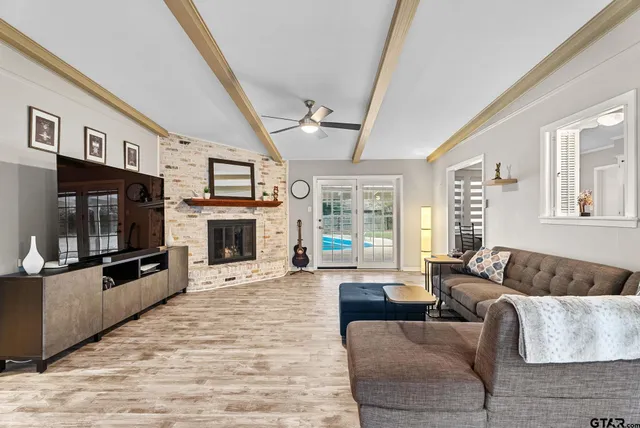 a living room with furniture a flat screen tv and a fireplace
