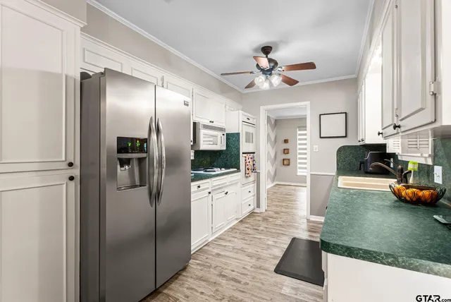 a large kitchen with stainless steel appliances kitchen island granite countertop a refrigerator and a stove top oven