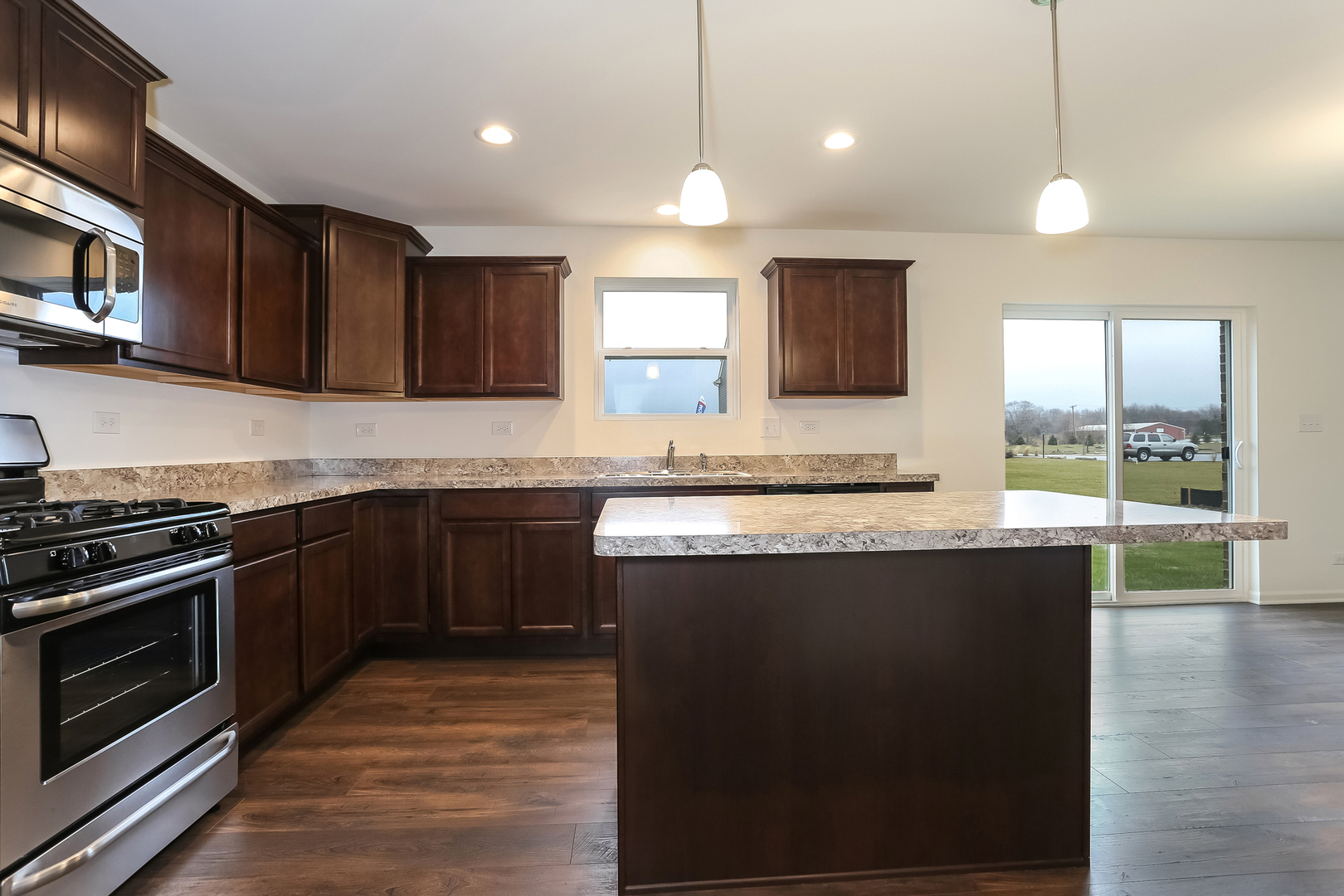2026 Rownham Hill Road New Lenox, IL 60451 - Photo 3 of 15 a kitchen with stainless steel appliances granite countertop a stove a sink and a microwave