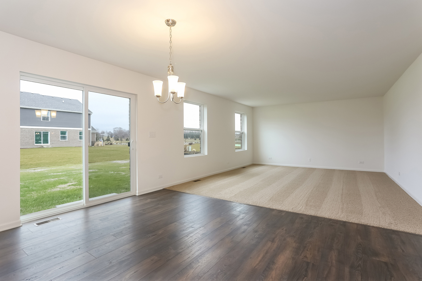 2026 Rownham Hill Road New Lenox, IL 60451 - Photo 8 of 15 an empty room with wooden floor mirror and windows