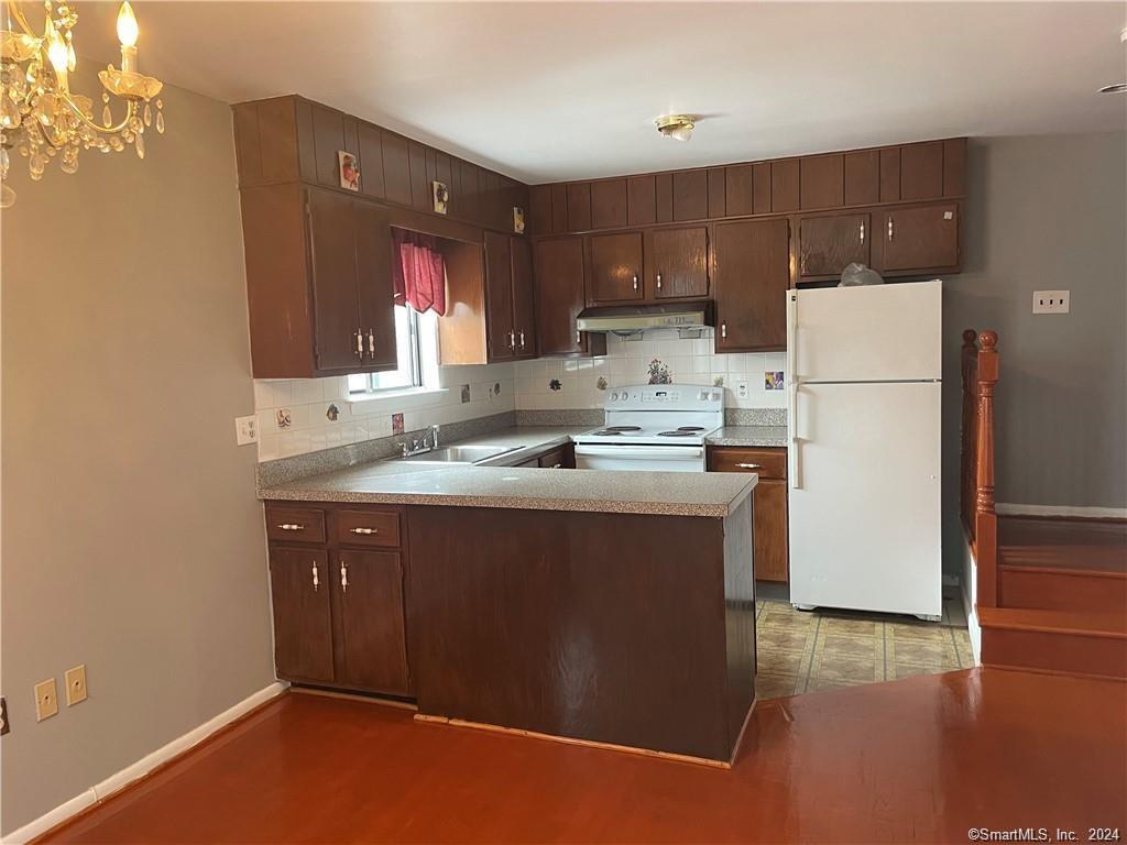 235 Cove Road, Unit 1 Stamford, CT 06902 - Photo 2 of 9 a kitchen with kitchen island a sink a stove a refrigerator and a oven