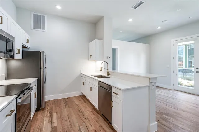 a kitchen with stainless steel appliances a stove microwave and sink