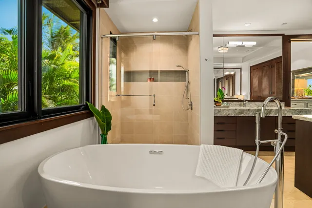 a bathroom with a granite countertop sink mirror and a bath tub