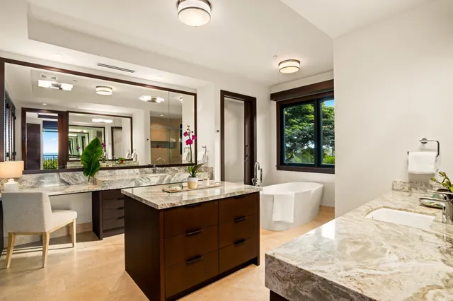 a bathroom with a granite countertop sink and a large mirror