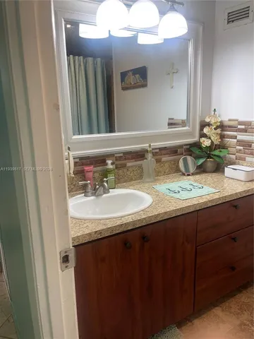 a bathroom with a granite countertop sink and a mirror