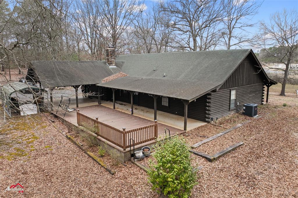 6951 Mira Myrtis Road Ida, LA 71044 - Photo 4 of 32 Rear view of house featuring a chimney, roof with shingles, and log exterior