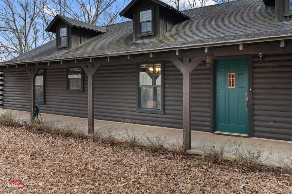 6951 Mira Myrtis Road Ida, LA 71044 - Photo 6 of 32 View of home's exterior with a patio, roof with shingles, and log exterior