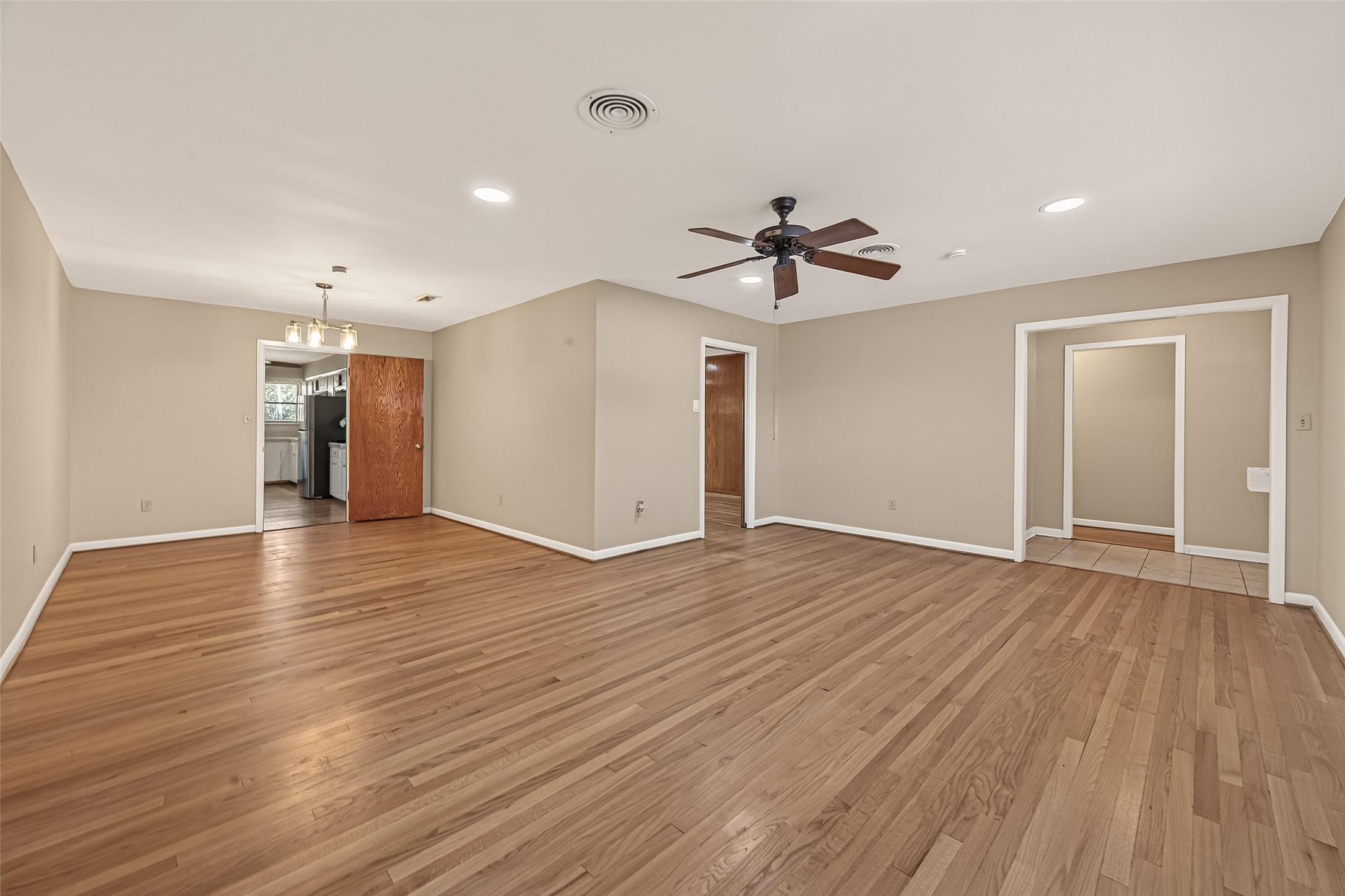 5646 Hazen Street Houston, TX 77081 - Photo 7 of 43 The spacious, open-concept living and dining area features warm wood flooring, neutral walls, and bright recessed lighting.