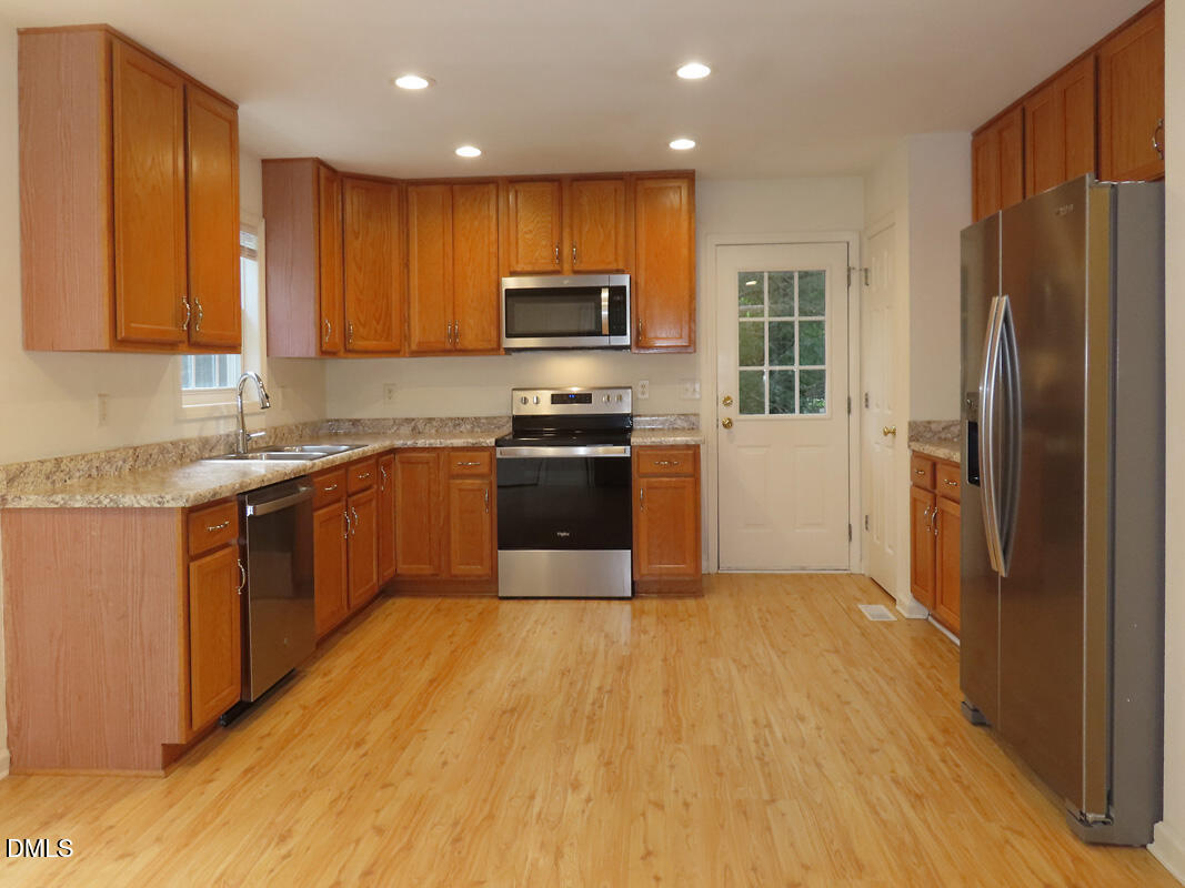 304 Davie Road Carrboro, NC 27510 - Photo 6 of 18 a kitchen with stainless steel appliances granite countertop a stove a sink dishwasher a refrigerator and a microwave