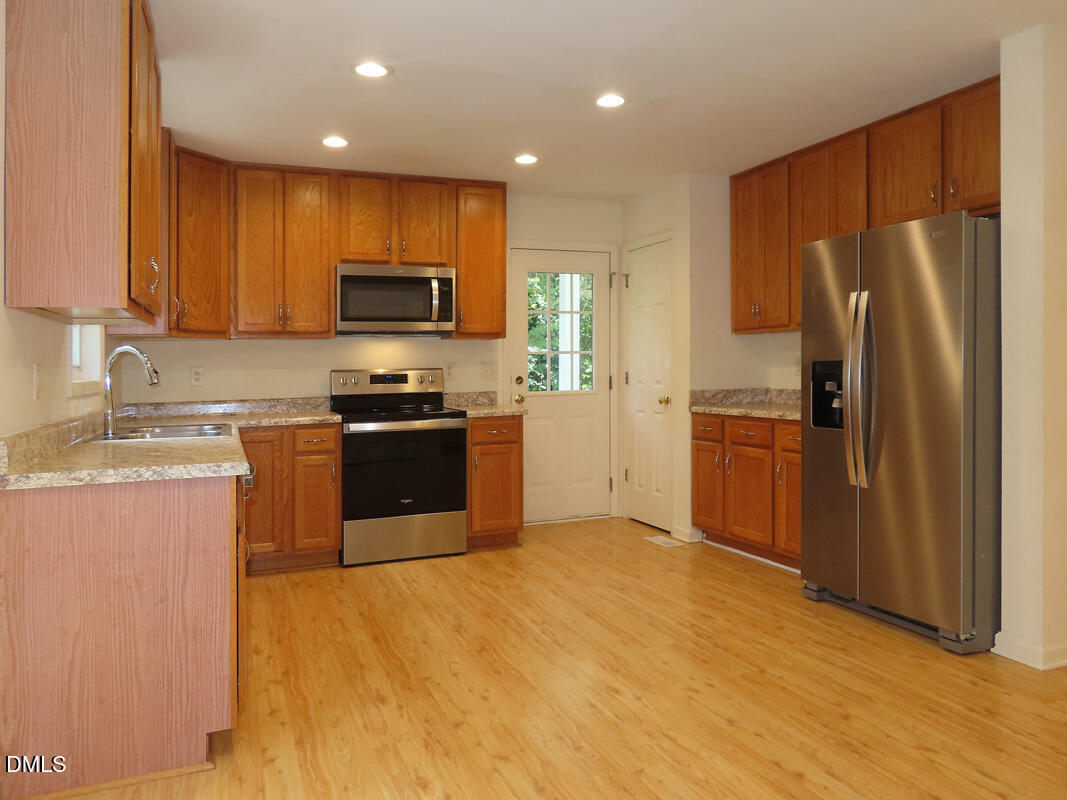 304 Davie Road Carrboro, NC 27510 - Photo 7 of 18 a kitchen with a refrigerator sink and wooden cabinets