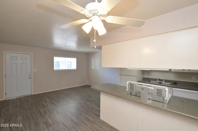a kitchen with stainless steel appliances granite countertop a sink a stove and a wooden floors