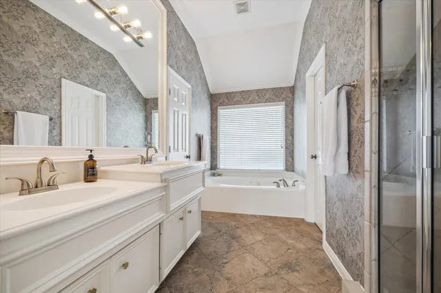 a spacious bathroom with a tub sink and a mirror