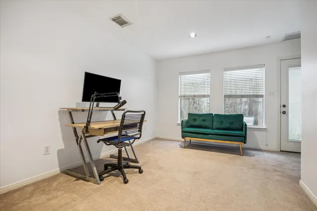 a view of a workspace with furniture and a window