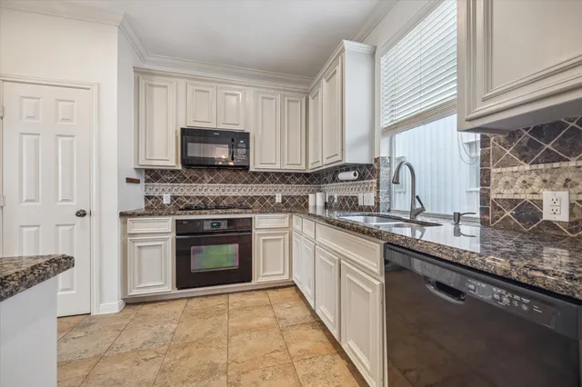 a kitchen with granite countertop a stove top oven sink and cabinets