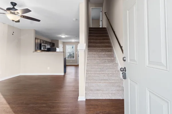 a view of a hallway with wooden floor and staircase