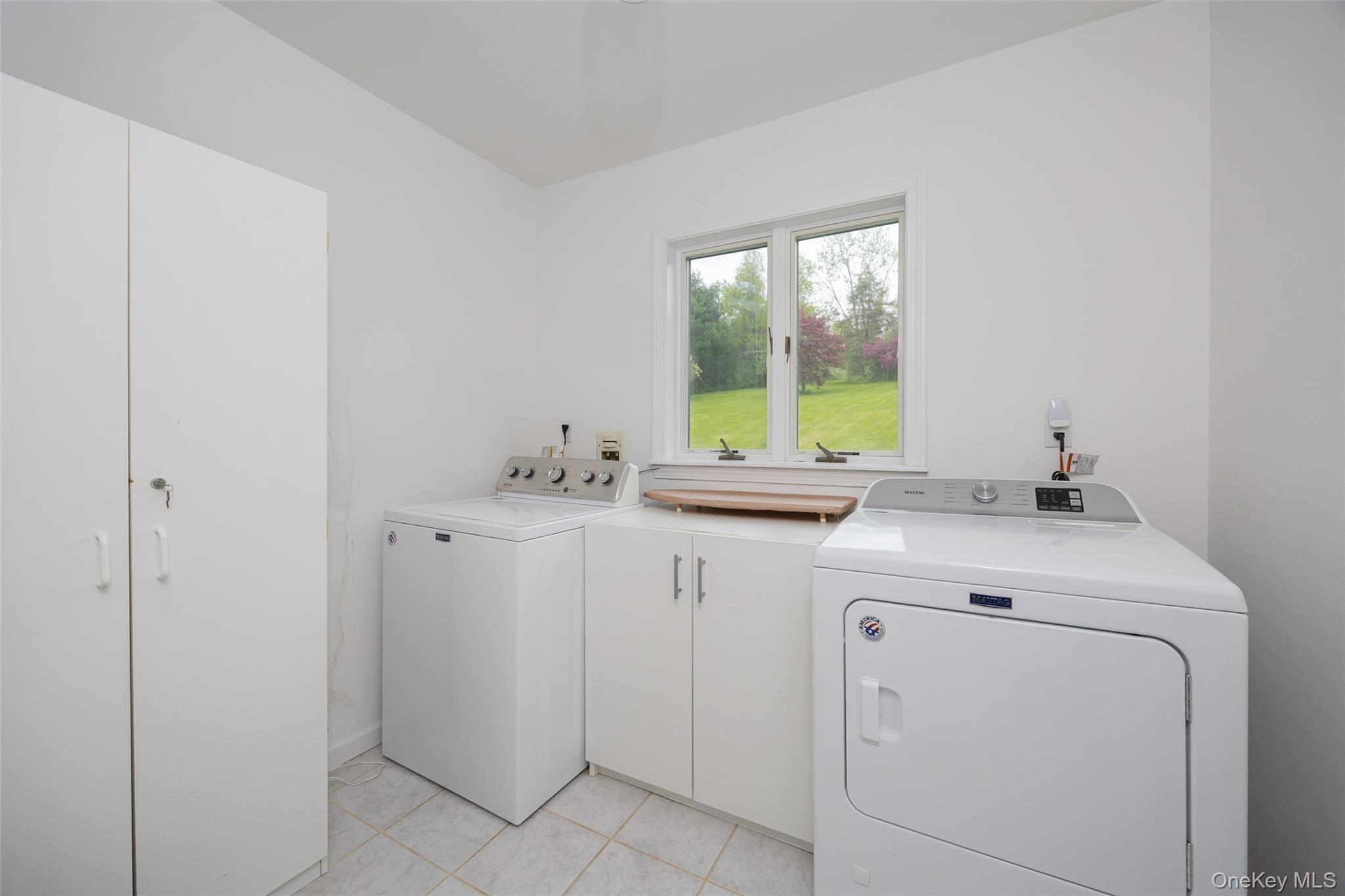 921 West Dover Road Pawling, NY 12564 - Photo 11 of 36 Dedicated laundry space featuring white cabinetry, a large window, tiled flooring, and a built-in countertop