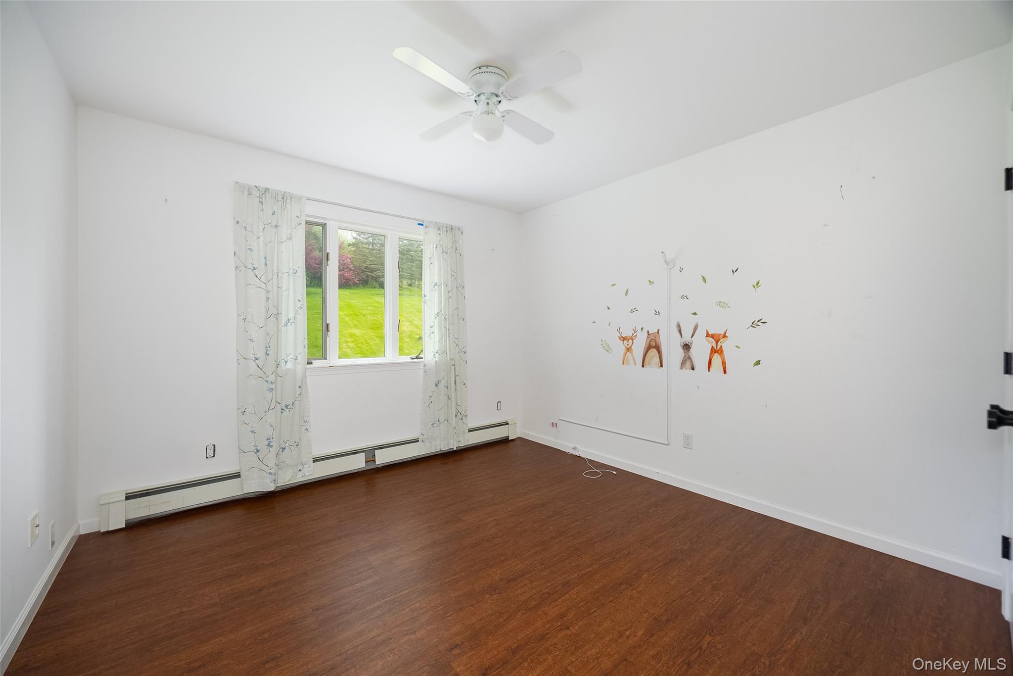 921 West Dover Road Pawling, NY 12564 - Photo 18 of 36 Bright interior space featuring wood-finish flooring, a ceiling fan, and a large window overlooking a verdant outdoor area