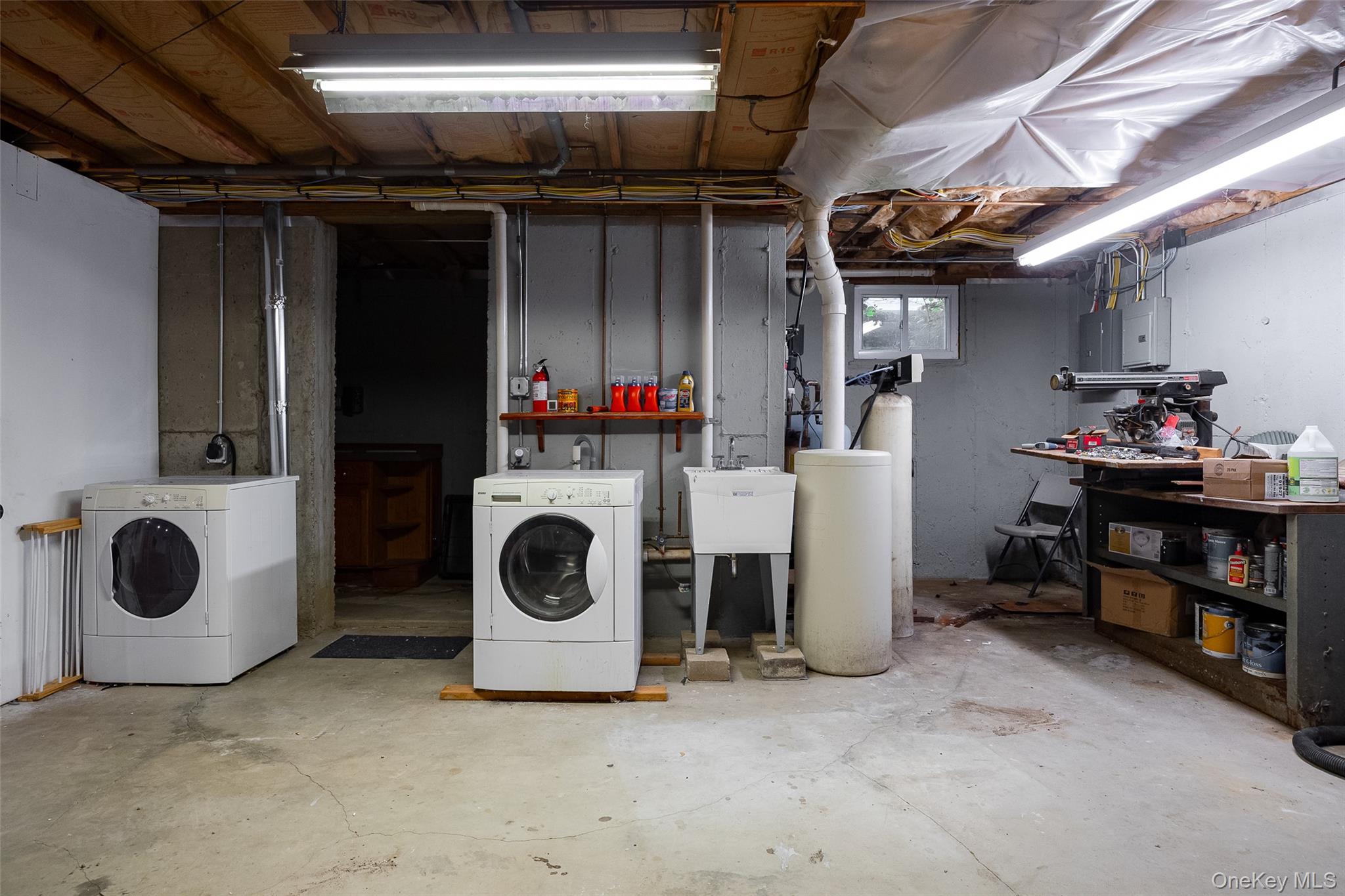 921 West Dover Road Pawling, NY 12564 - Photo 31 of 36 Utility room featuring exposed ceiling joists, concrete flooring, a wall-mounted utility sink, and visible plumbing