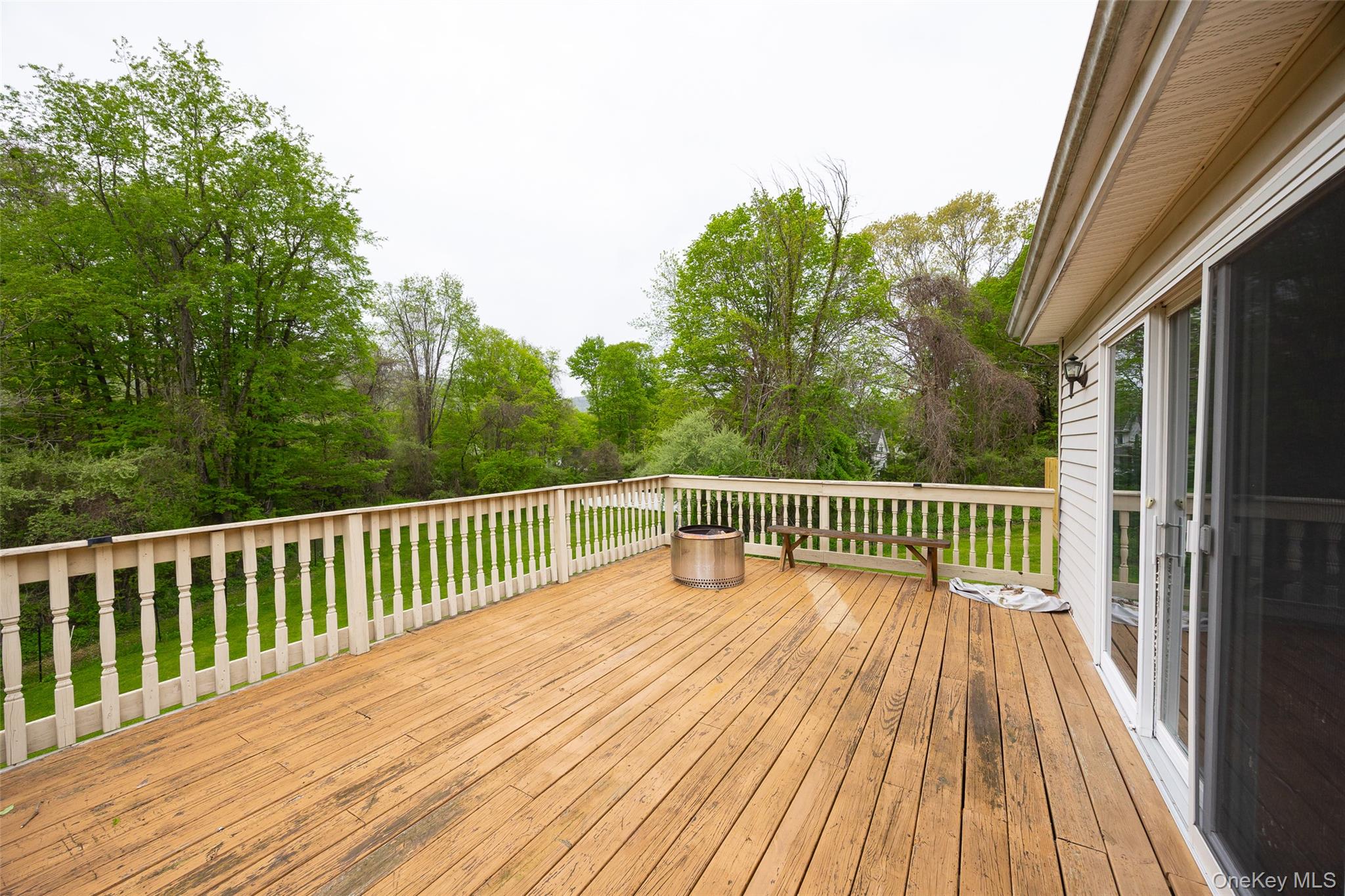 921 West Dover Road Pawling, NY 12564 - Photo 32 of 36 Expansive wood deck featuring a white spindle railing and direct access to interior spaces via sliding glass doors