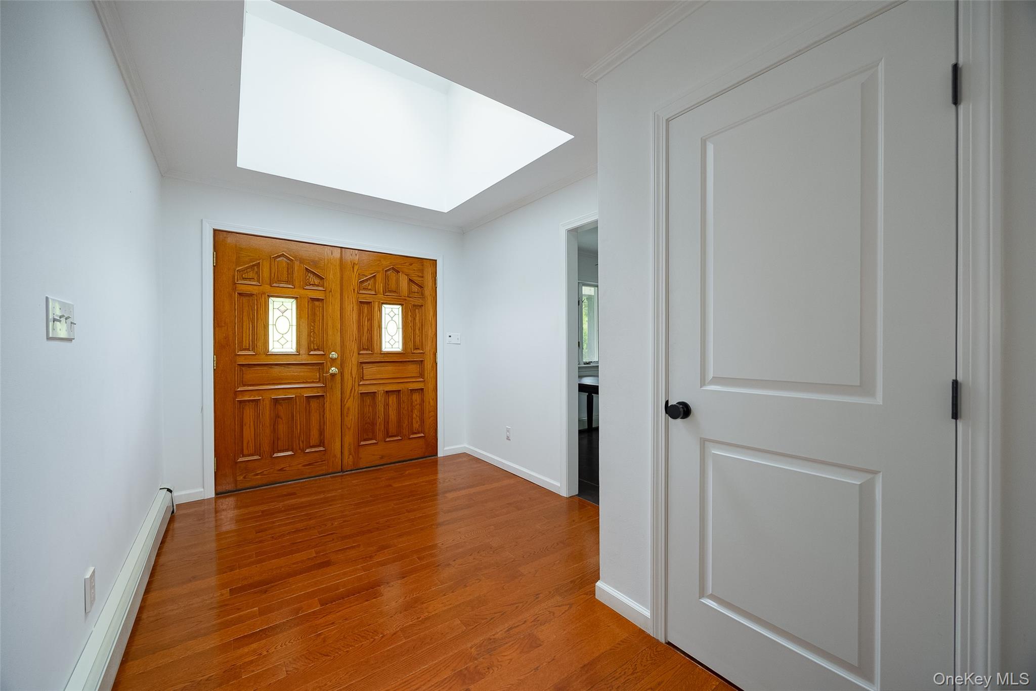 921 West Dover Road Pawling, NY 12564 - Photo 4 of 36 Entryway featuring double wood entry doors with decorative glass panels, wood-finish flooring, a skylight, and white walls