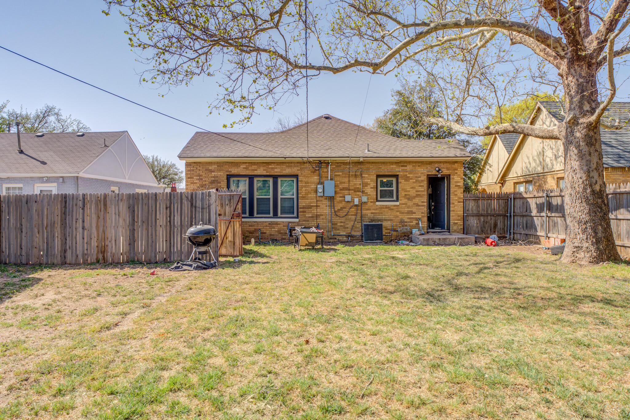 2606 22nd Street Lubbock, TX 79410 - Photo 24 of 24 a view of a house with a large tree and wooden fence