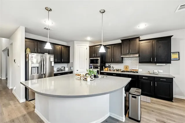 a kitchen with kitchen island a sink appliances and cabinets