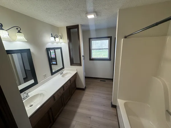 a bathroom with sink a mirror and a bathtub
