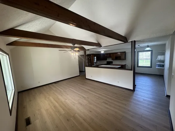a view of a hallway with wooden floor and white cabinet