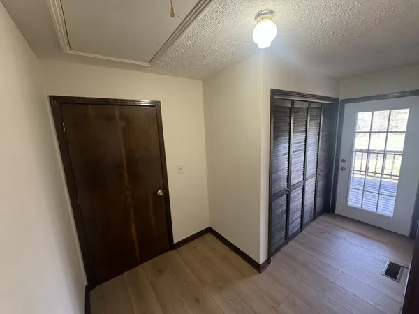 wooden floor in a hall with an entryway and a window