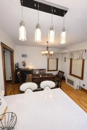 a living room with furniture a chandelier and kitchen view
