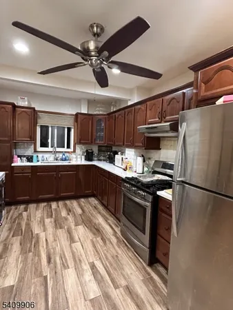 a kitchen with stainless steel appliances granite countertop a refrigerator a sink a stove and a microwave