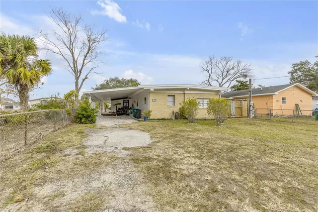 a view of a house with a big yard and large tree