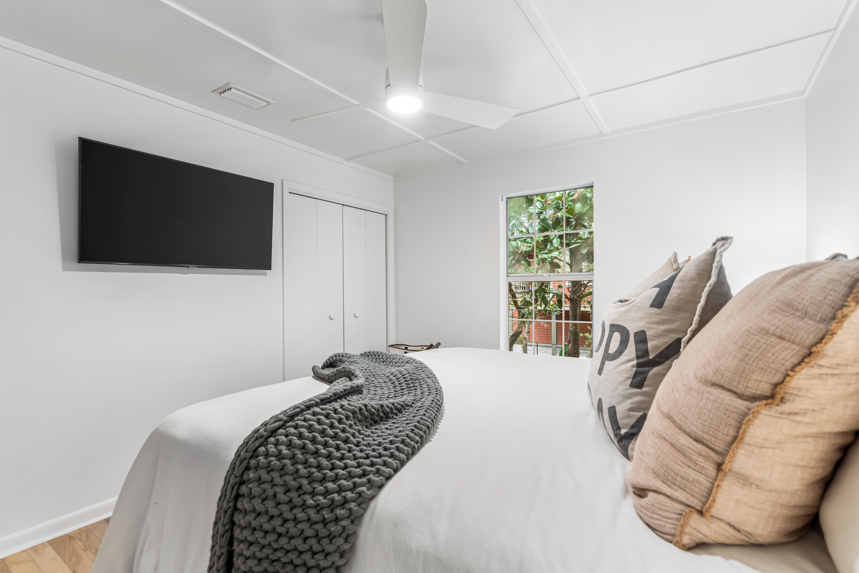 345 Defuniak Street Santa Rosa Beach, FL 32459 - Photo 23 of 52 a bedroom with a bed a flat screen tv and a large window
