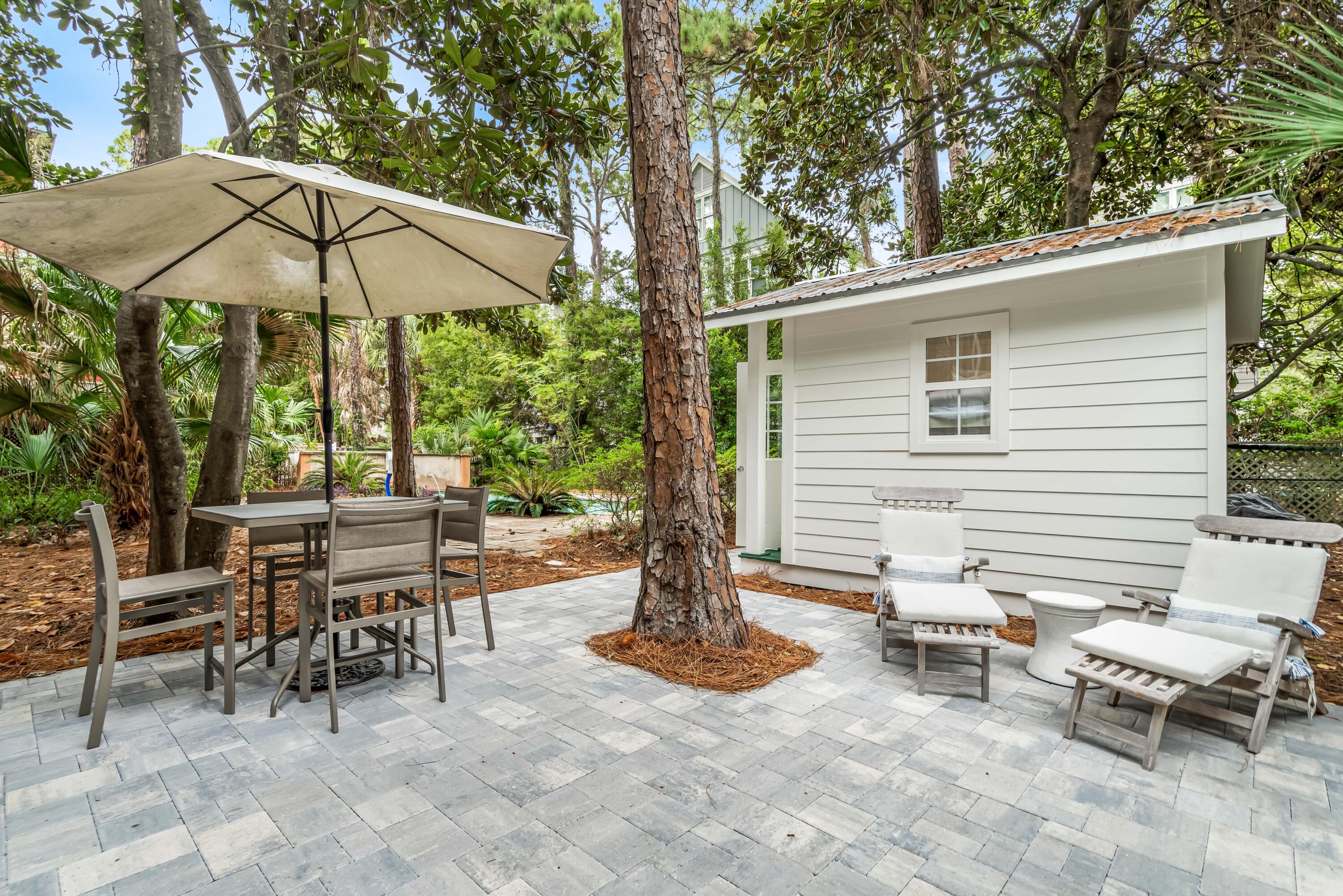 345 Defuniak Street Santa Rosa Beach, FL 32459 - Photo 32 of 52 a view of a patio with a table and chairs under an umbrella