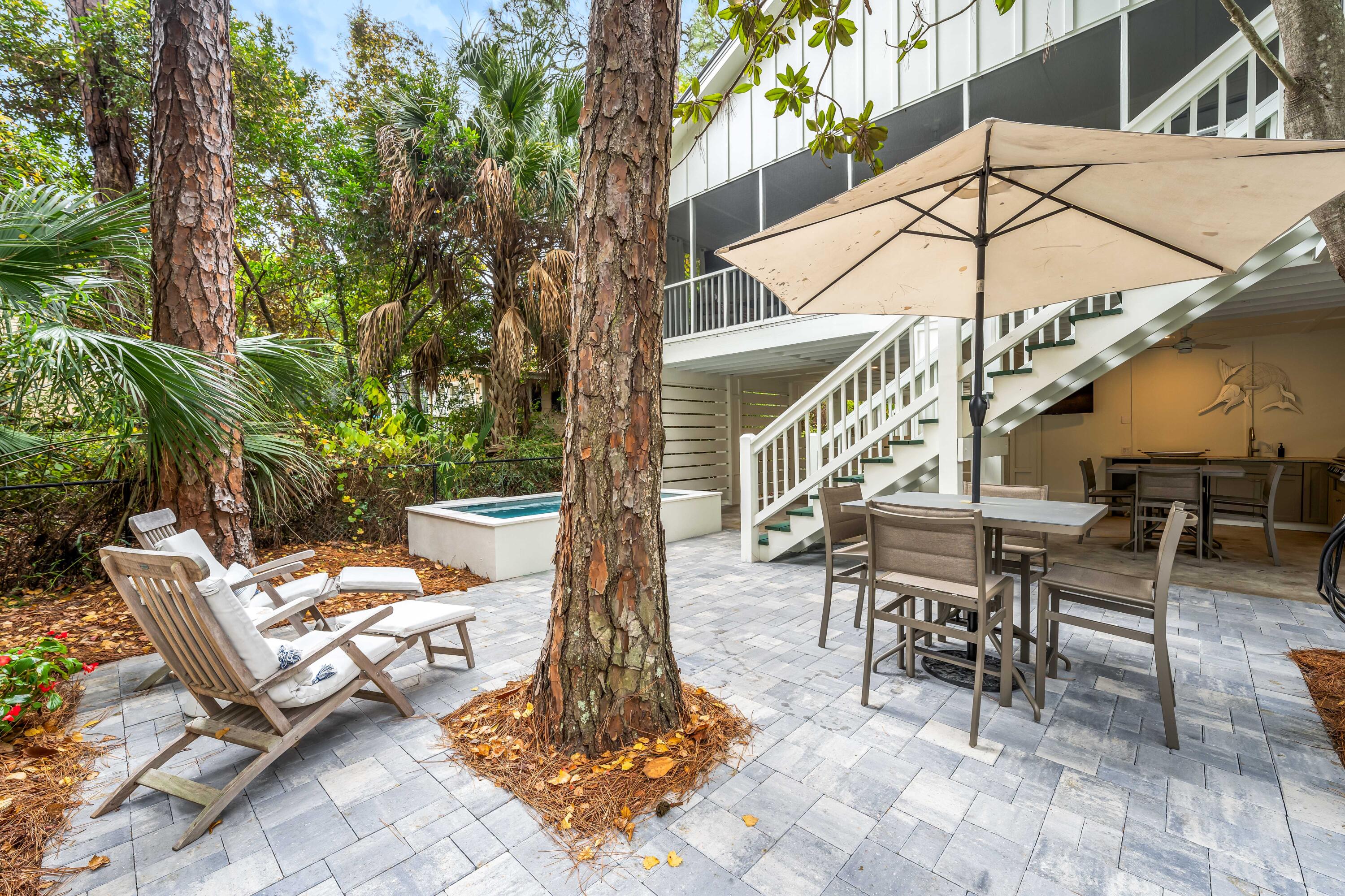 345 Defuniak Street Santa Rosa Beach, FL 32459 - Photo 46 of 52 a view of a patio with a dining table and chairs